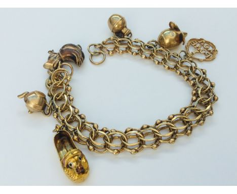 A 9ct yellow gold wire link bracelet with 6 x charms including a mouse, a duck and a teapot, measuring 8 inches, weighs 24.1 