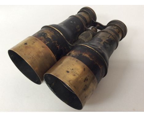 A pair of early 20th century naval binoculars, one of the sliding brass object lens shades engraved 'Rear Admiral Charlton.' 
