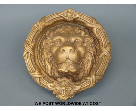 A brass or similar lion mask door knocker of unusually large proportions, width 23cm