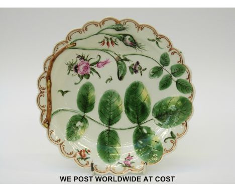 A first period Worcester Blind Earl plate c1770 with painted flowers, relief moulded leaves and roses and gilded detail to th