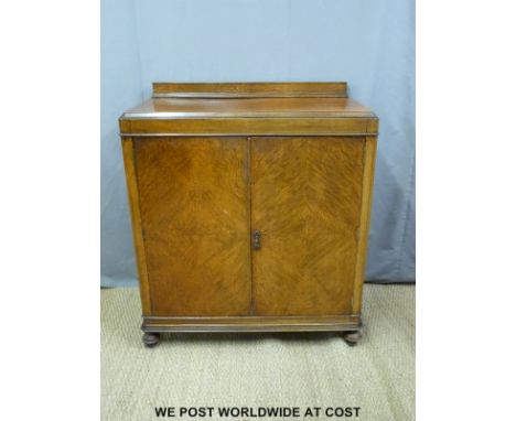 An oak cabinet with two drawers and shelf within raised on bun feet (H110 x W101 x D50cm)