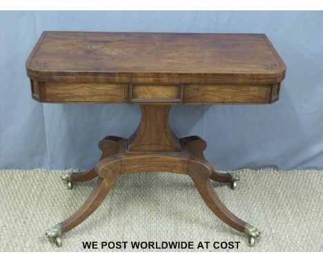 A 19thC line inlaid mahogany fold over card table on a moulded support raised on a quatrefoil base and brass castors (H70 x W