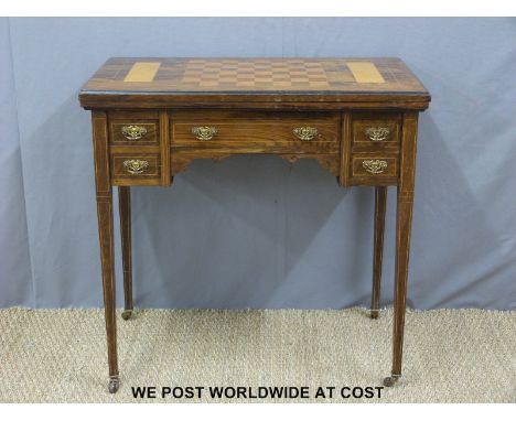A late 19th/20th century inlaid rosewood ladies desk with fold over top to form a games table, five drawers with ornate brass