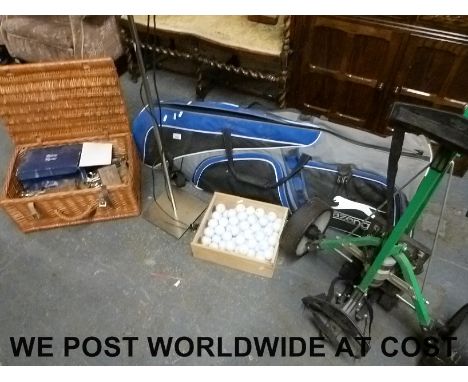 A set of golf clubs, twenty golf balls, motorised trolley, lamp, and a Fortnum & Mason hamper with tools