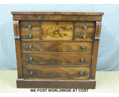 A 19thC flame mahogany chest of seven graduated and one central deep drawer with mother of pearl inlay to the turned handles,