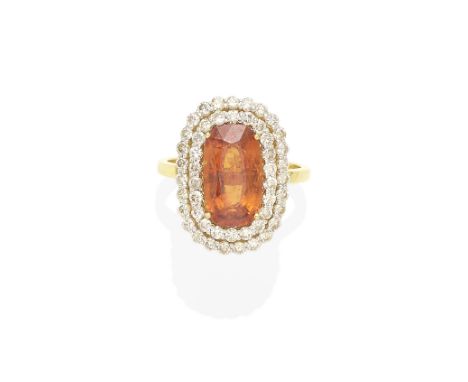 A spessartite garnet and diamond ringcentering an oval-cut spessartite garnet weighing approximately 5.35cts; mounted in 18k 