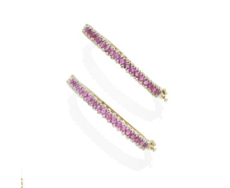 a pair of gold, diamond and ruby bangles mounted in 14k bi-color gold; estimated total diamond weight: 1.00ct; gross weight a
