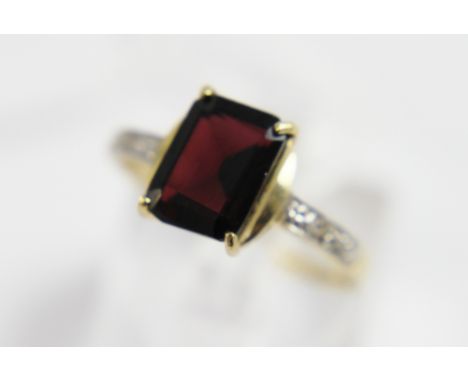 9ct gold ring with emerald cut garnet and diamond set shoulders, size O