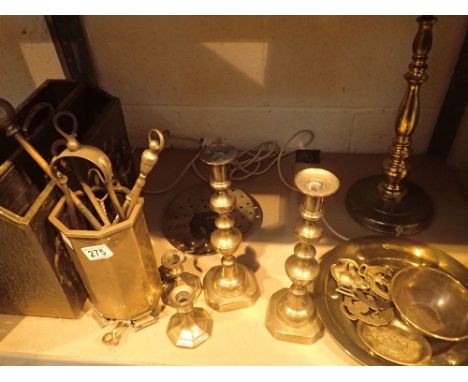 Shelf of brass items incliuding paper rack, companion set, candlesticks