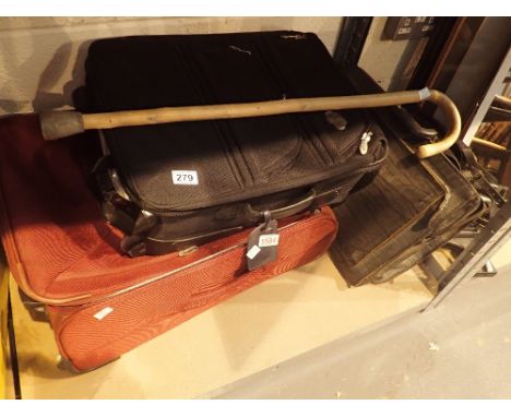 Two suitcases and a briefcase with a selection of linen and a walking stick 