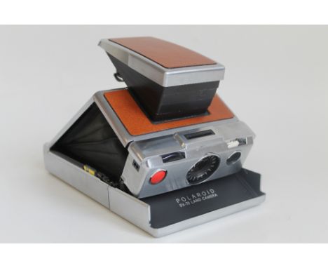 A POLAROID SX-70 LAND CAMERA, in brown leather case. 