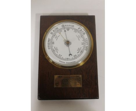 AN OAK CASED ANEROID BAROMETER, white enamel face. Brass presentation plaque of Montgomeryshire Constabulary DATED 1932. 38cm