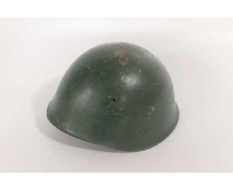 AN ITALIAN STEEL COMBAT HELMET, GREEN PAINTED SHELL, WITH ORIGINAL LEATHER LINER AND CHIN STRAP. The liner marked in black 'O