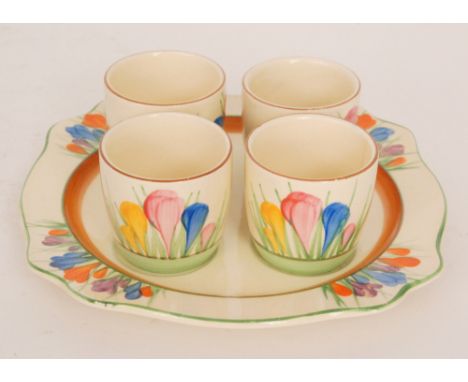 Clarice Cliff - Crocus - An egg cup set circa 1932 with a Leda shape plate and four later Spring Crocus egg cups all hand pai