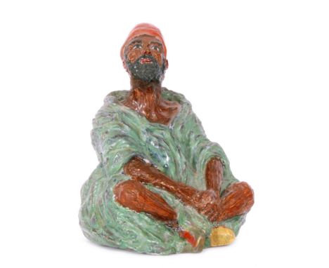 Clarice Cliff - Arab - An early A.J.Wilkinson hand modelled figure by Clarice Cliff of a seated Arab figure in green robes, p