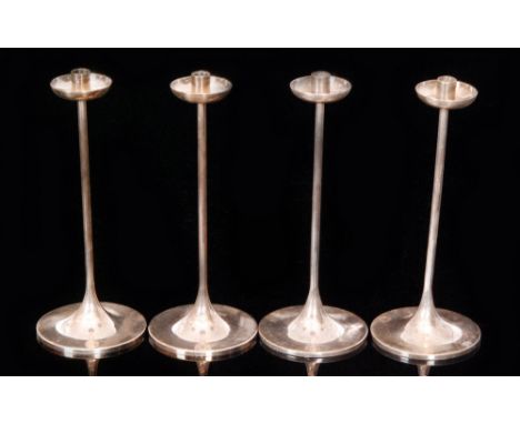 In the manner of Robin Welch - Old Hall - A set of four silver plated taper sticks each with a wide spread foot leading to a 