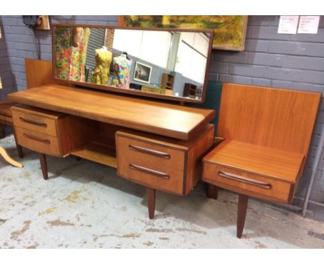 In the manner of G-Plan - A teak chest of six long drawers with recessed handles above a plinth base, height 103cm, together 