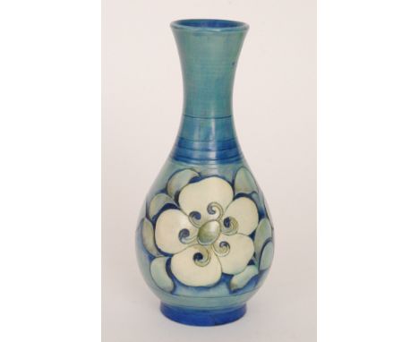 William Moorcroft - A salt glazed bottle vase decorated with stylised flowers and foliage, all in tones of blue and cream, im