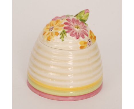 Clarice Cliff - Marguerite - A Beehive honey pot circa 1934 with a floral relief moulded cover picked out in tonal pink, yell