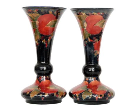 William Moorcroft - A pair of Pomegranate pattern vases, each of compressed ovoid form with a flared trumpet neck, each decor