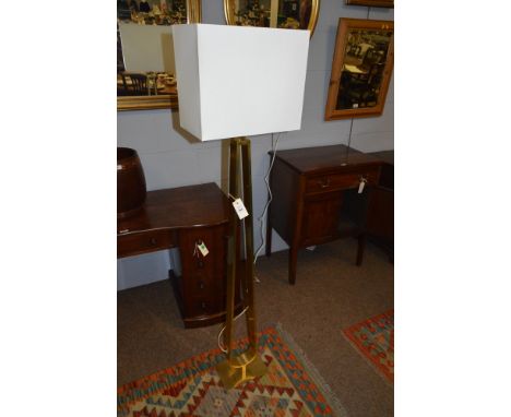 A contemporary glass standard lamp with rectangular cream coloured shade.