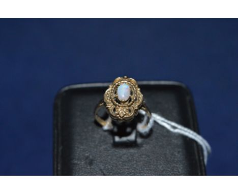 An opal ring, set in 9ct yellow gold open scroll mount and shank, ring size P.