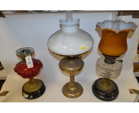 Three duplex oil lamps, to include: brass lamp with red glass reservoir; brass lamp with white glass shade; and brass lamp wi
