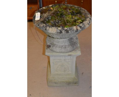 A cast composition garden urn standing on a square moulded plinth base, 49cm diameter and 74cm high overall.
