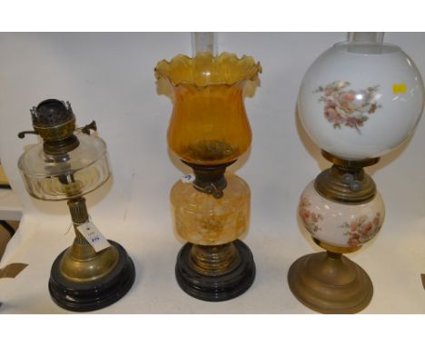 Three duplex oil lamps, to include: brass column style lamp with clear glass reservoir; a brass lamp with ceramic reservoir a