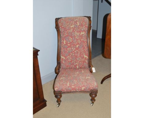 A Victorian high back easy chair with ornately carved exposed mahogany framework, the seat and back upholstered in tapestry p