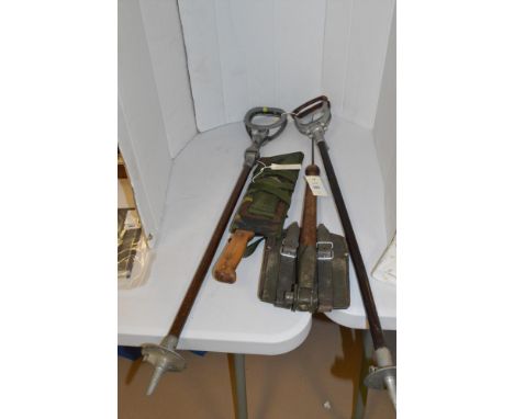 Two shooting sticks; a trench shovel with leather cover; and a machete by Martindale, Birmingham, with cammo scabbard.