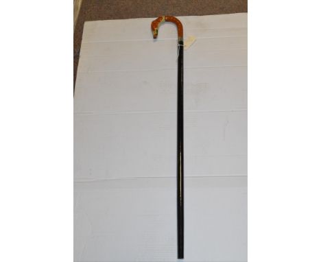 An ebonised walking stick with carved and painted dog head handle.