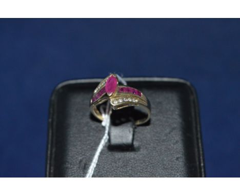 Ruby and diamond ring, the marquise cut ruby flank by central bank of further rubies, brilliant cut diamonds above and below,