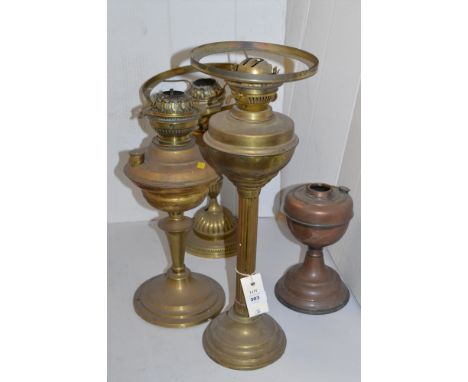 Three brass oil lamps; together with a smaller copper oil lamp.