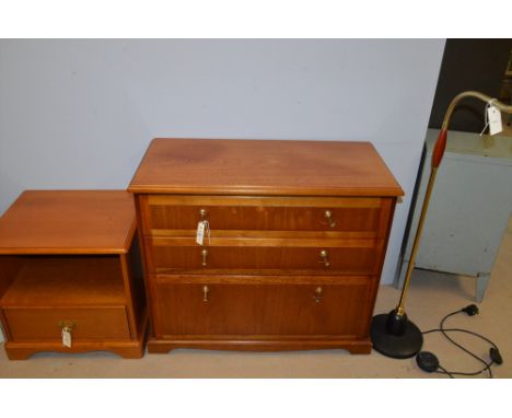 A modern teak chest of three drawers; and a near matching bedside cabinet; and an angle-poised standard lamp.