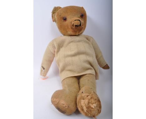 A vintage mid 20th Century Merrythought teddy bear soft toy. Of typical form with wear commensurate with age, with knitted to