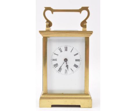 A 20th century brass cased carriage clock with white dial and brass movement, brass handle above escapement. Measures 13cm ta