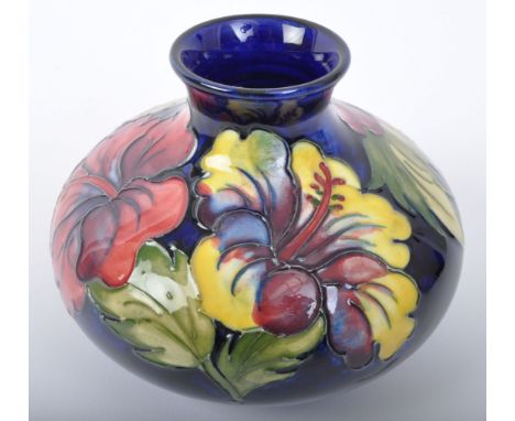 A vintage 20th Century Moorcroft hibiscus squat vase. Having a circular flared top bulbous body with floral decoration on a b