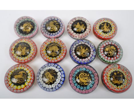 A collection of twelve vintage 20th century Italian Murano glass paperweights having sulfur boule zodiac decoration to the ce