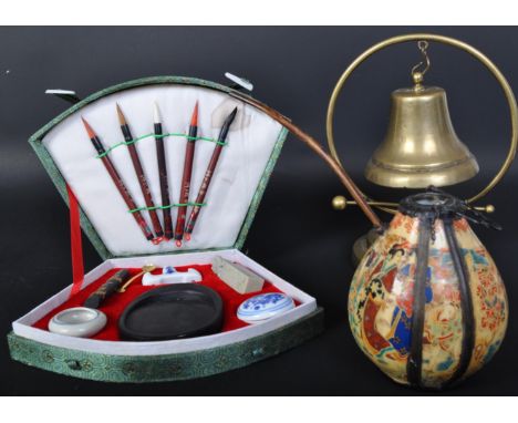 An assortment of 20th century Chinese items to include a brass table top bell on stand, a ceramic Chinese metal mounted hand 