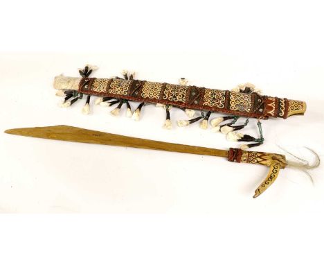 A Dyak Mandau (Headhunter's Sword), with later gilt painted steel blade, painted bone hilt and wood scabbard trimmed with tuf