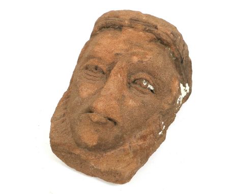 A Celtic Red Stone Mask, carved with deep set eyes, wrinkled eye bags and down-turned mouth, 22cmNose, forehead and cheeks. c