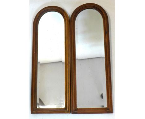 A pair of early 20th century mahogany arch topped mirrors with bevelled plates, 64 x 23cm 