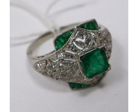 A platinum emerald and diamond ring centrally set with a square stepped-cut emerald to further emeralds and brilliant-cut dia