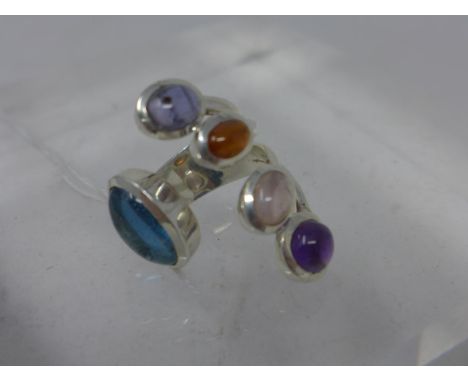 A sterling silver ring set with cabochon blue topaz, amethyst, moonstone, garnet and iolite, ring: 3.5 x 2.5cm, Size: O, 13.8