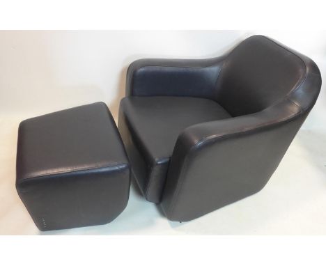 A black leather armchair and foot stool 