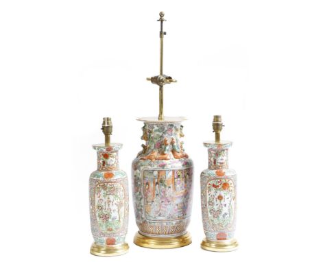 A pair of Chinese porcelain table lamps, painted with flowers, figures, bats and trees, with gilt highlights and on a giltwoo