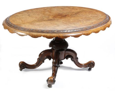 A Victorian walnut and marquetry loo table, the oval quarter and burr veneered tilt-top inlaid with flowers, leaves and strin