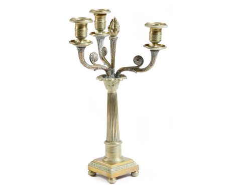 An early 19th century gilt brass candelabrum, with three leaf decorated scroll branches, with drip-pans and fish scale decora