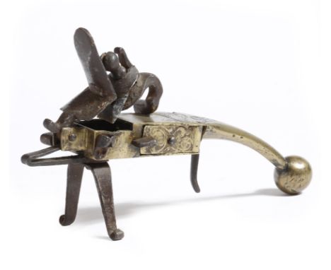 An 18th century brass and iron tinder lighter, engraved with scroll decoration and with a ball foot, 18.8cm long.Click here t